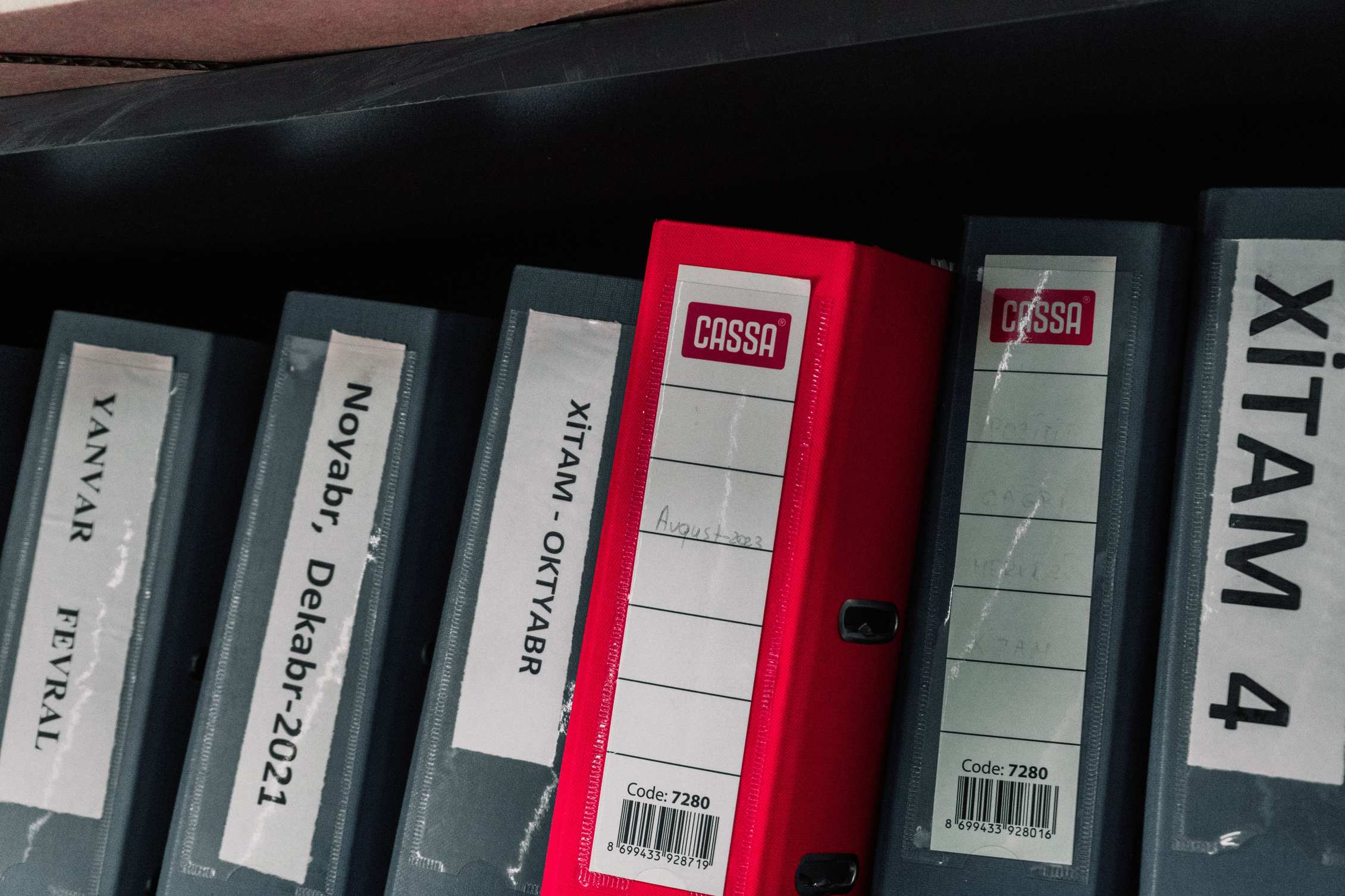 Farblich sortierte Aktenordner in einem Archivregal